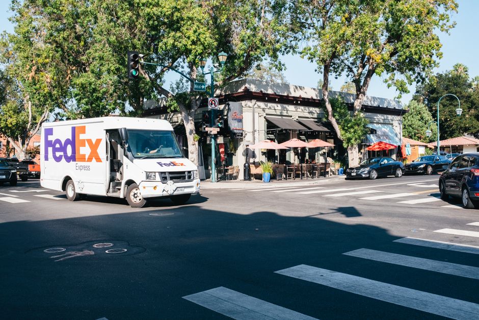 White same day courier van driving through city